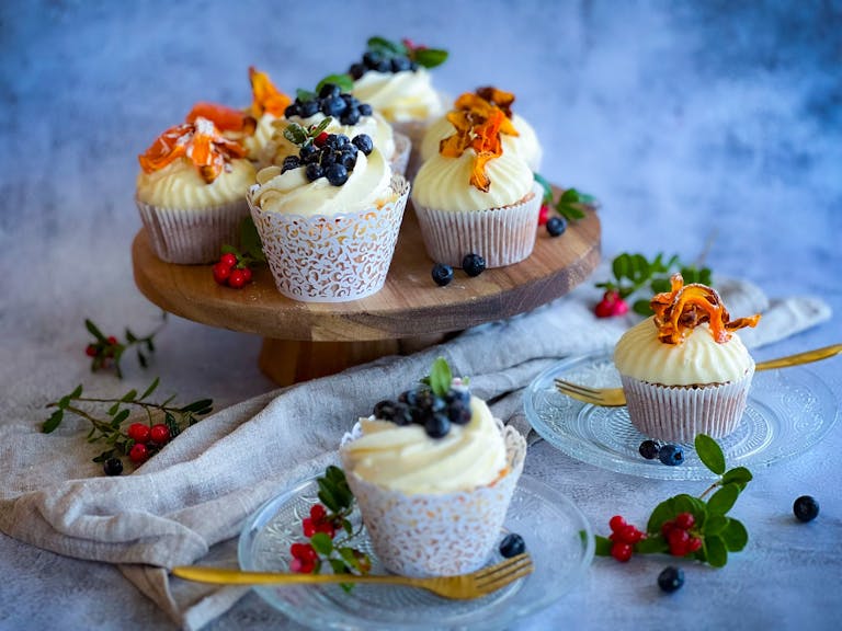 Aesthetic cupcakes topped with blueberries on a rustic stand, perfect for dessert inspiration.